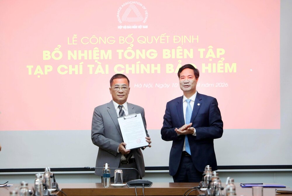 Ông Nguyễn Xuân Việt, Chủ tịch Hiệp hội Bảo hiểm Việt Nam trao quyết định bổ nhiệm cho nhà báo Nguyễn Phong Cầm. Ảnh: Tuấn Minh