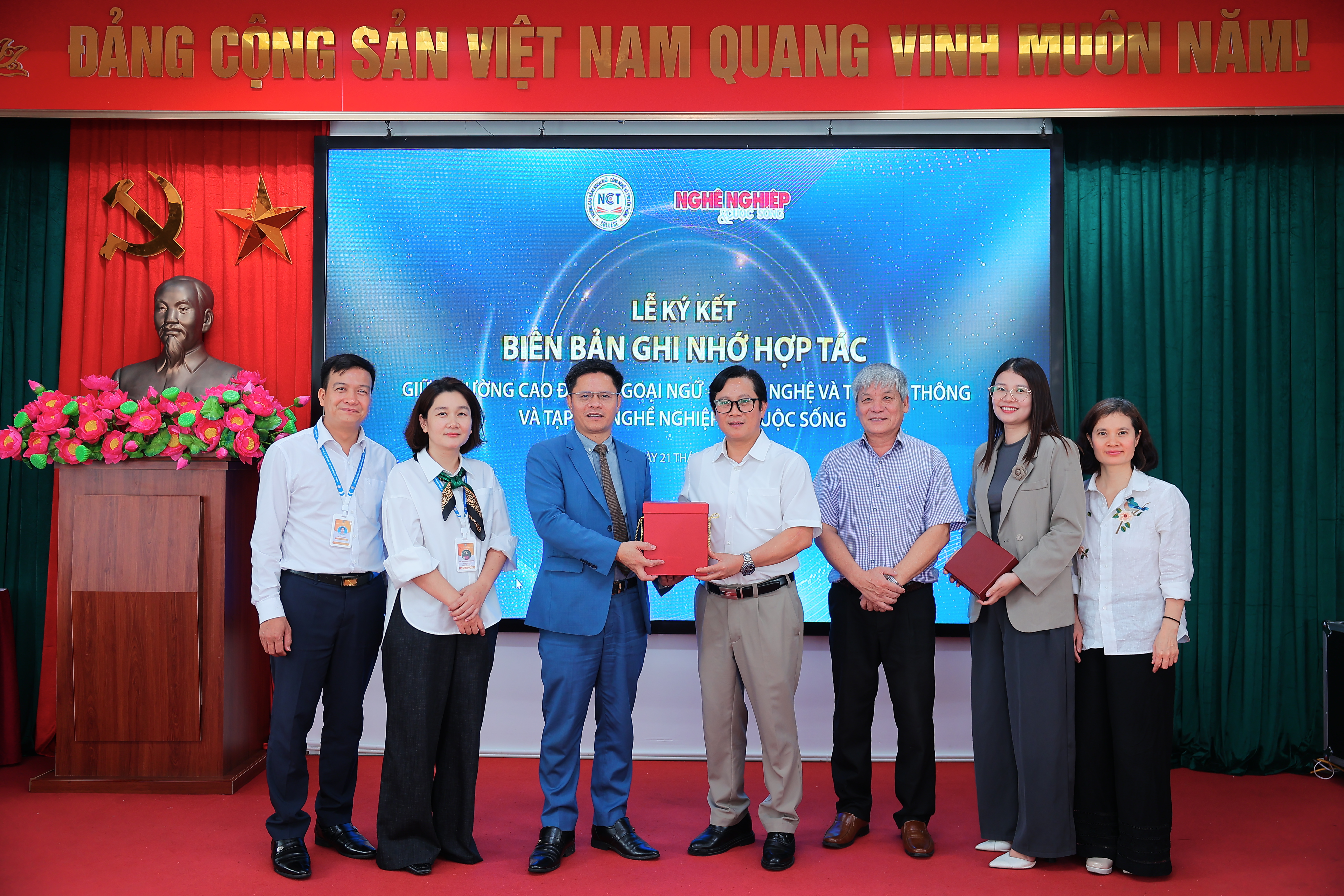 Tổng Biên tập Tạp chí Nghề nghiệp và Cuộc sống, ông Lê Anh Đạt (áo trắng) tặng quà lưu niệm cho trường CĐ Ngoại ngữ - Công nghệ và Truyền thông. 