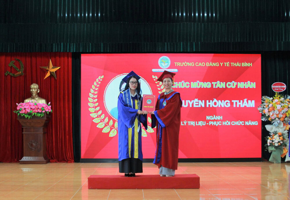 TS.Nguyễn Thị Thu Dung, Hiệu trưởng nhà trường ( phải) trao Bằng tốt nghiệp cho sinh viên. 